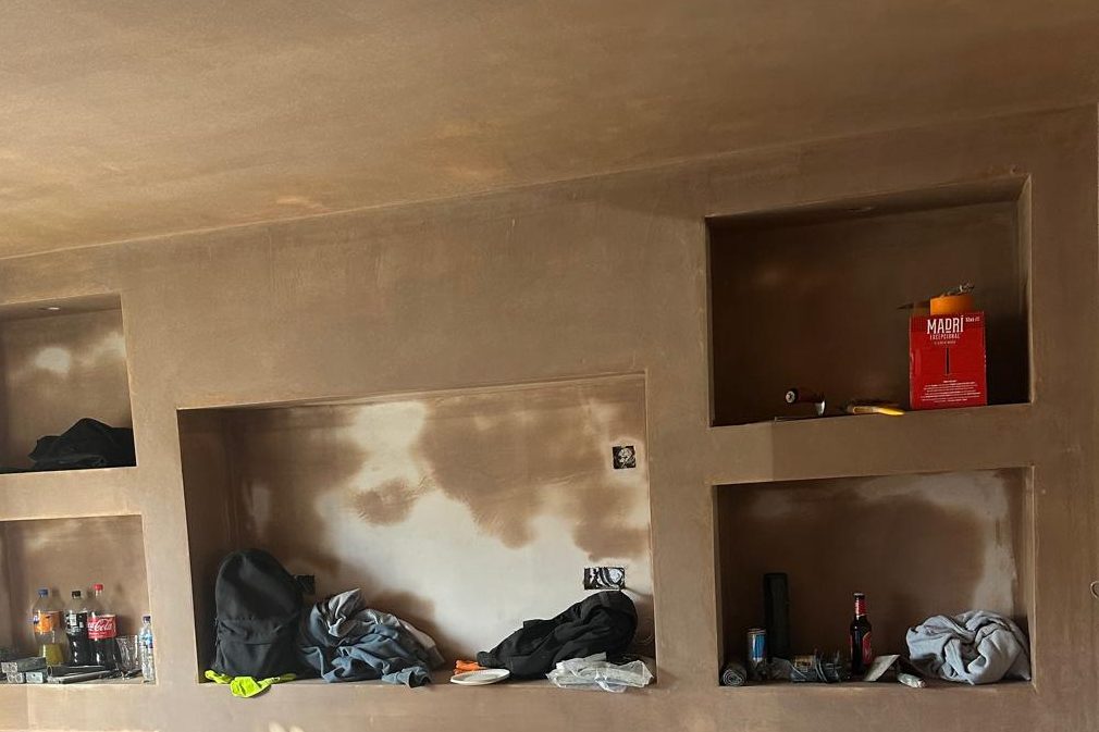 A built-in media wall with plastered recesses and niches. Photographed during finishing.